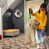 Dziewczyna wyprowadzająca psa na spacer, w tle Omlet Topology leGowisko dla psa z poduszką z fasoli i białymi stopami na szynach