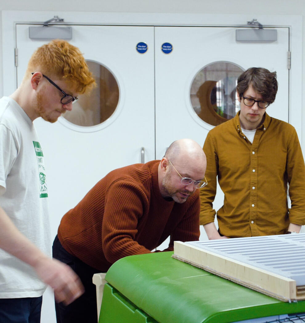 Czterech mężczyzn badających kurnik Eglu Cube w warsztacie